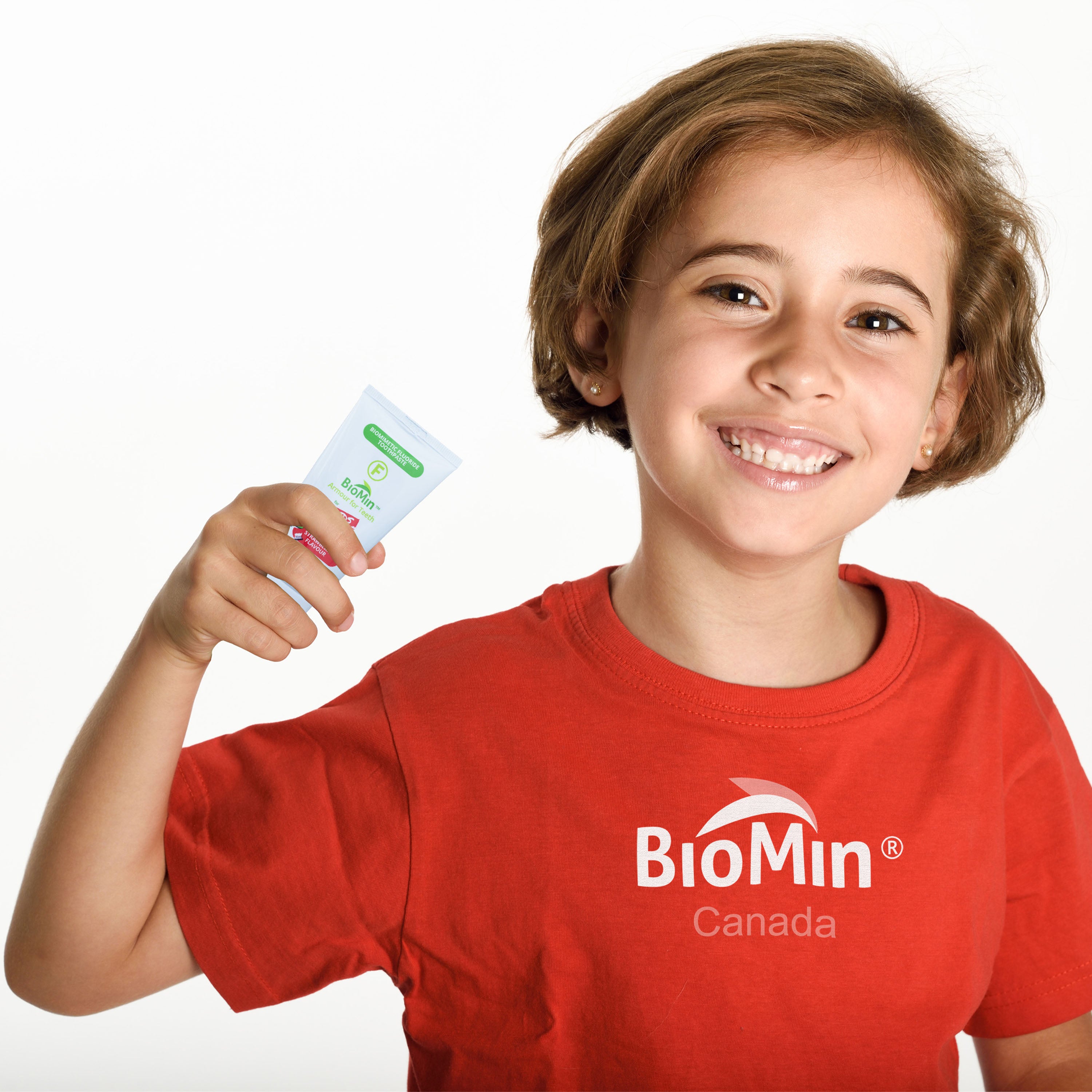 Child wearing a red BioMin Canada shirt holding a product against a white background
